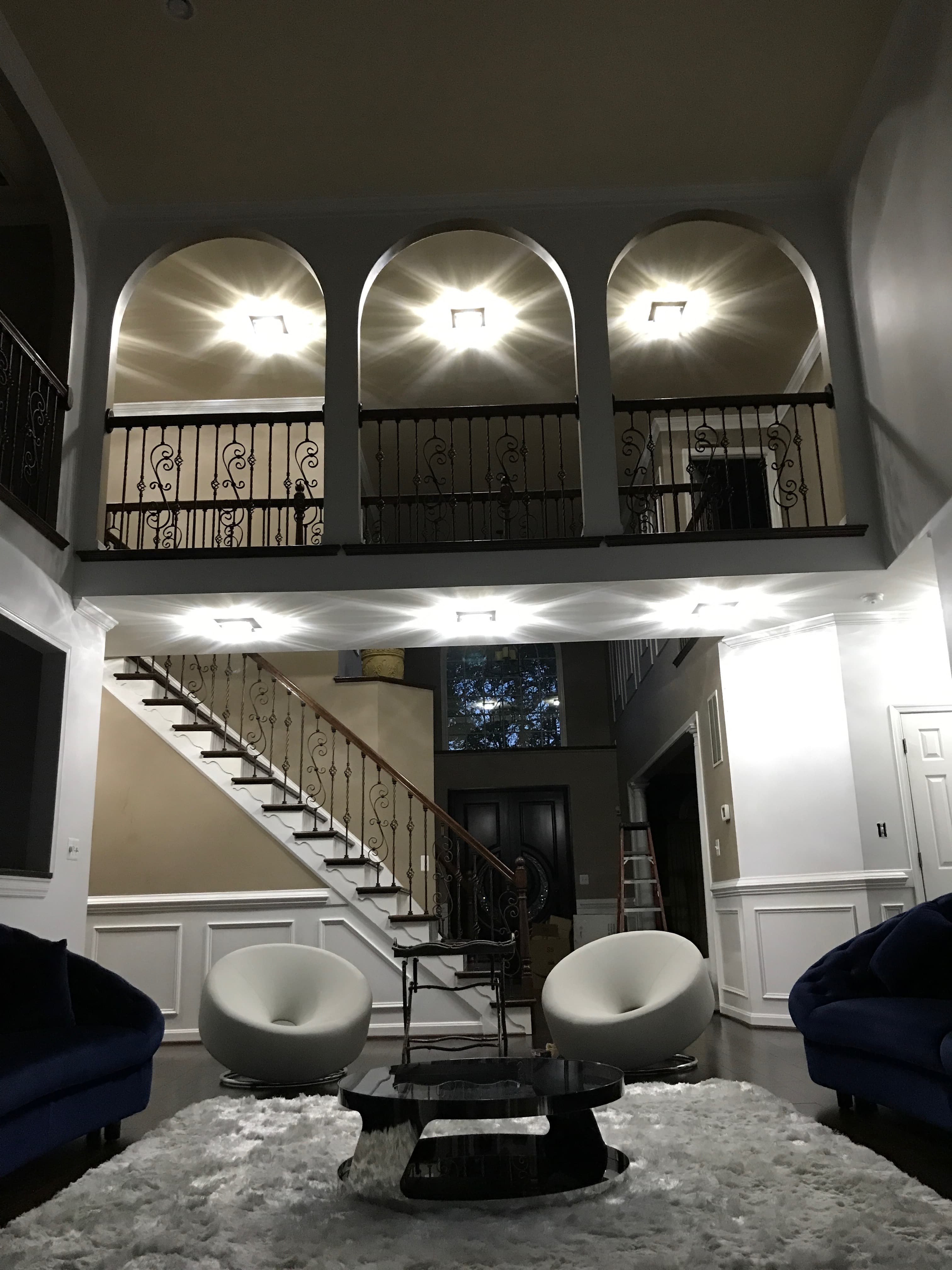 Luxury residential interior renovation with custom iron staircase and dramatic lighting in Maryland by Atlantic Construction