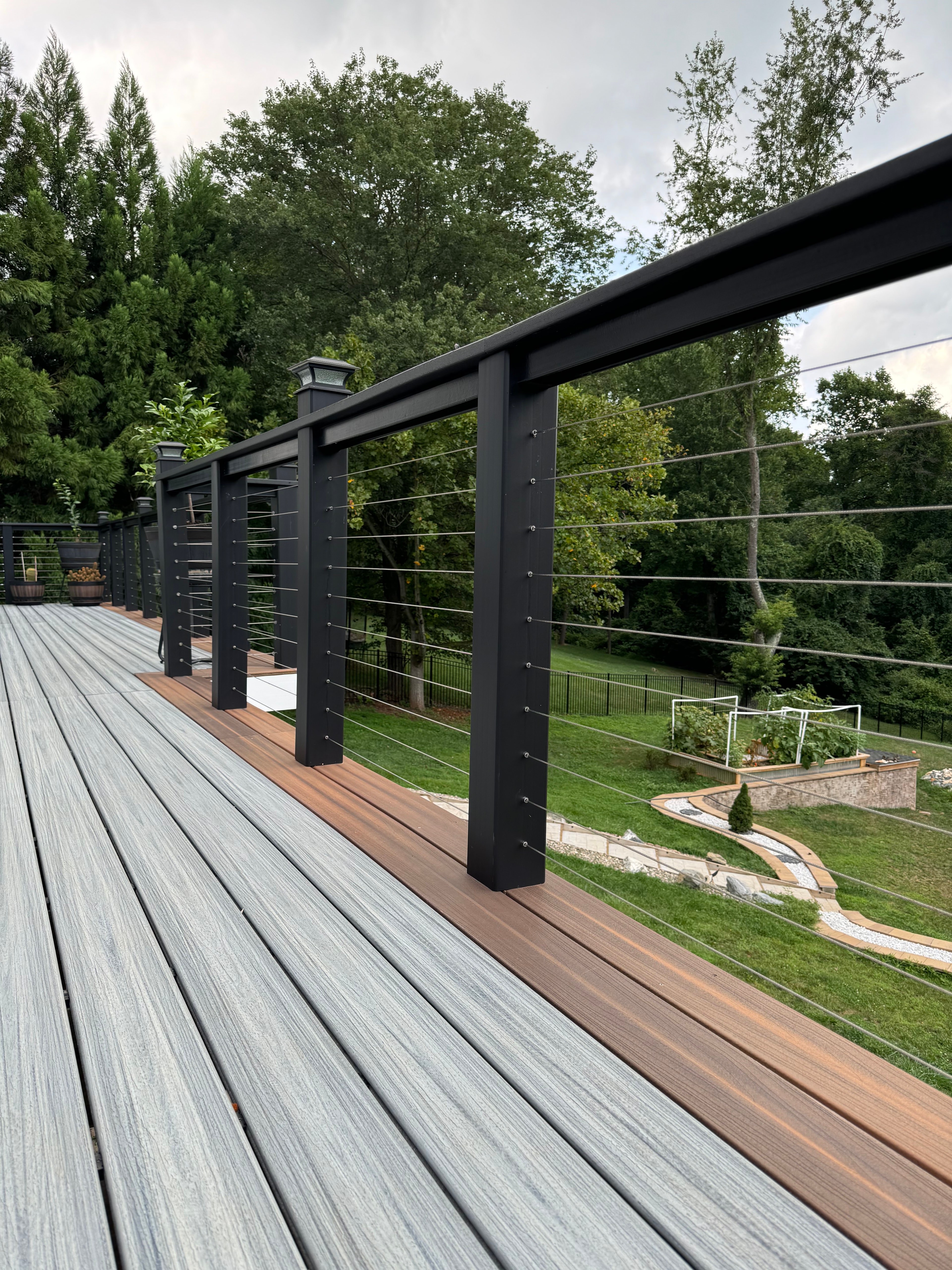 Modern residential deck with black cable railing and composite decking in Maryland by Atlantic Construction