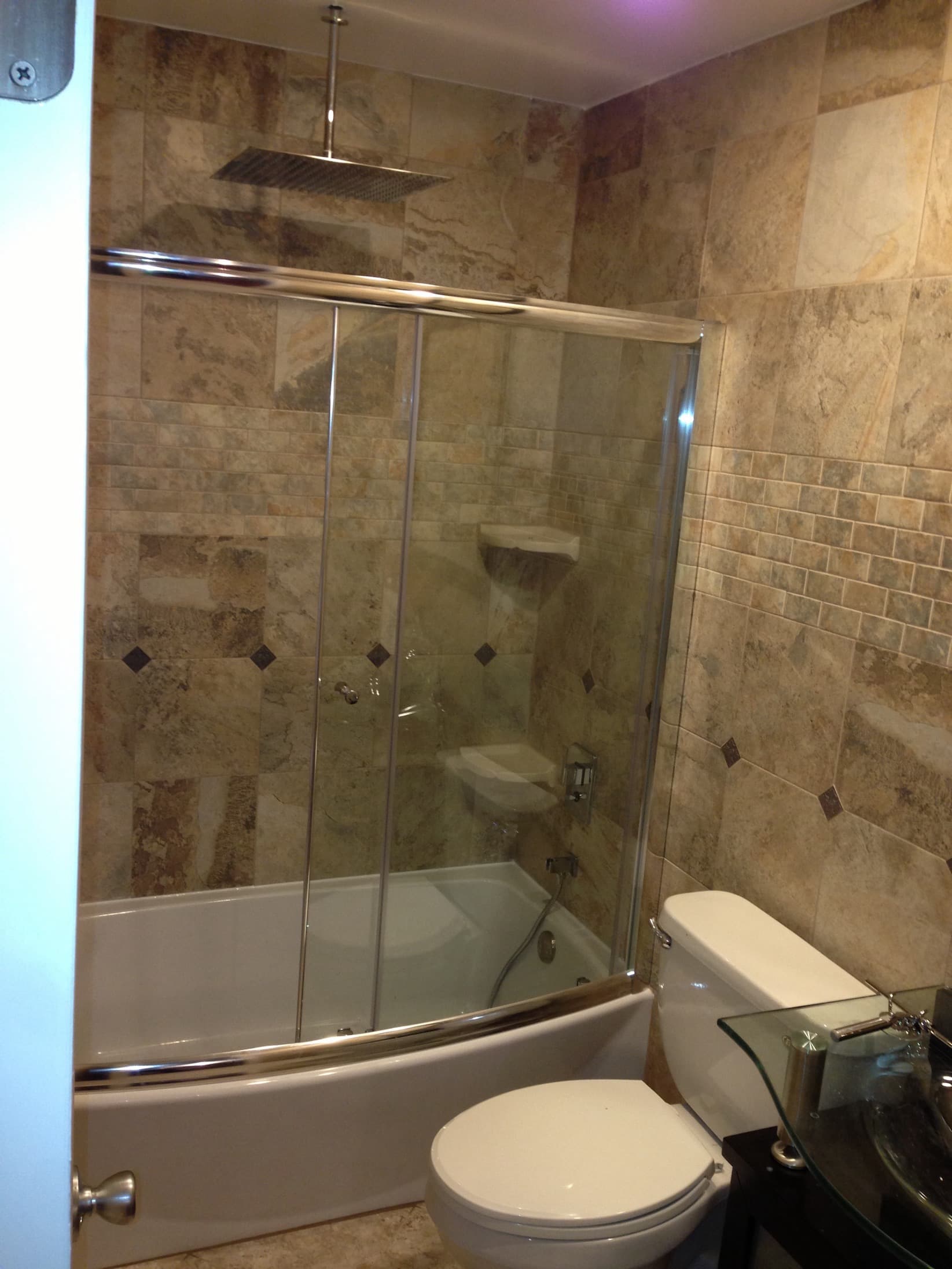 Luxury bathroom with travertine tile tub and shower combo in Maryland by Atlantic Construction