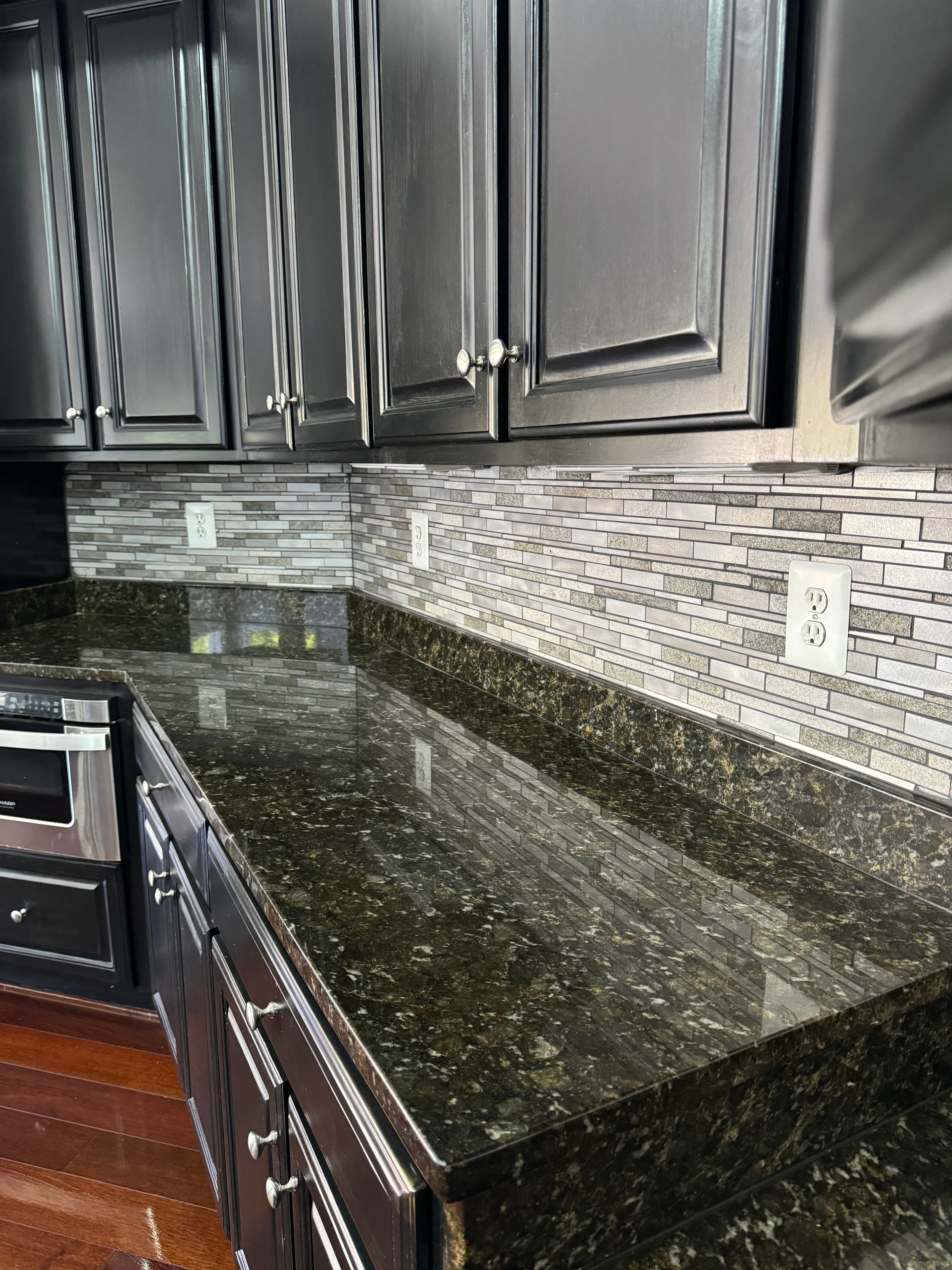 Luxury kitchen renovation with emerald green granite countertops and glass tile backsplash in Maryland by Atlantic Construction